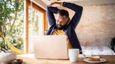 
		Man at desk stretches neck
	